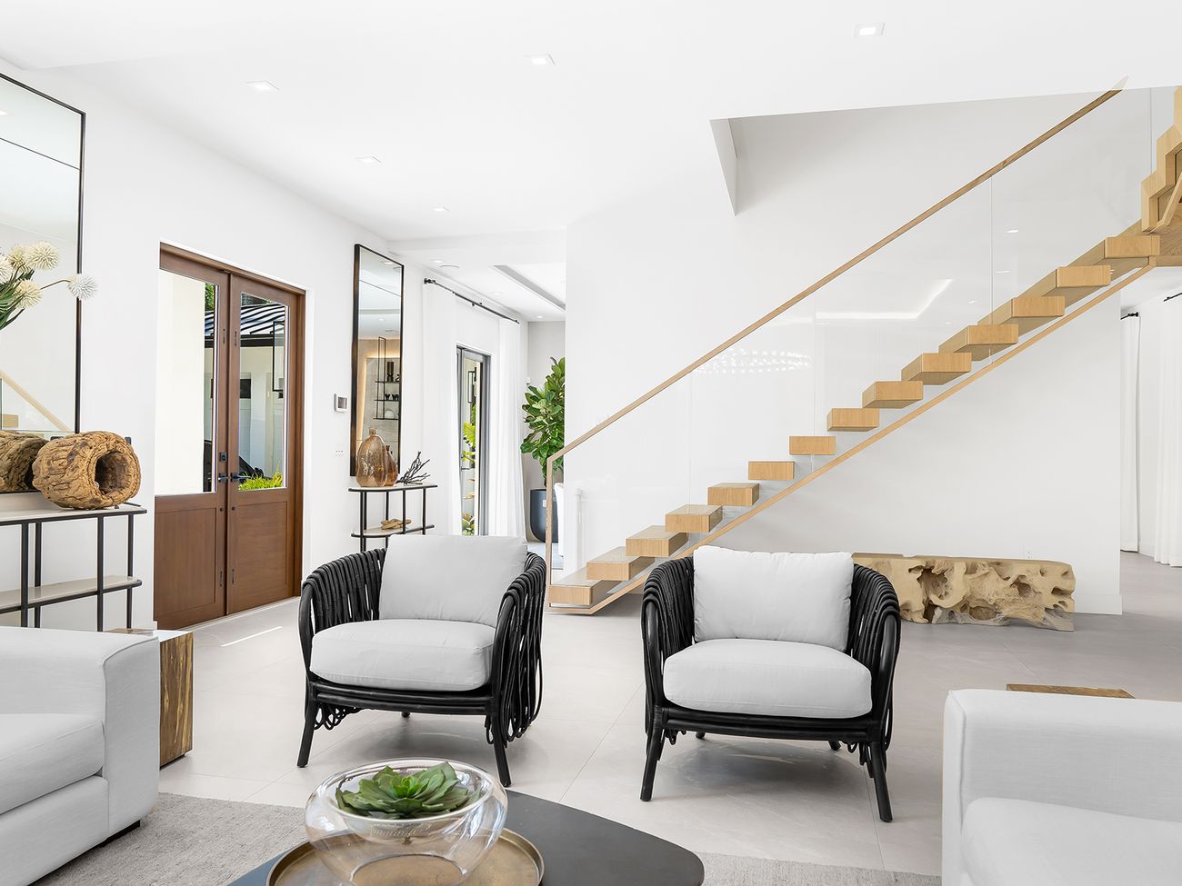 Entry with floating white-oak stair and wood front doors