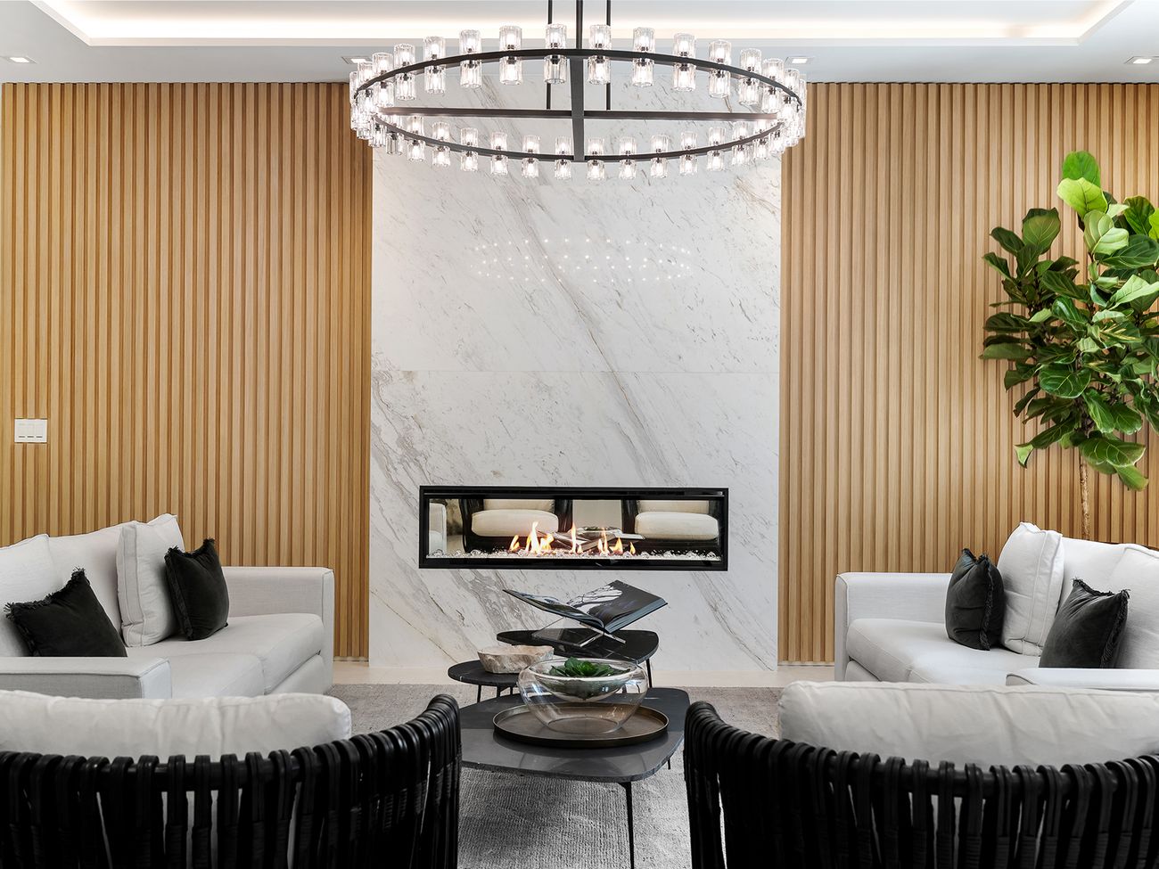 Living room with book-matched marble fireplace wall and white-oak slats